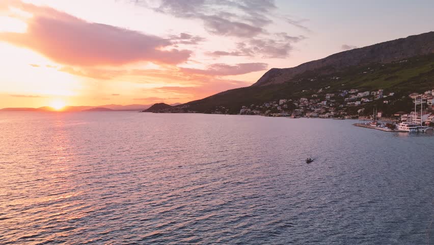 Colorful vived sunset over the sea in Croatia with the silhouette of the riding motor boat 