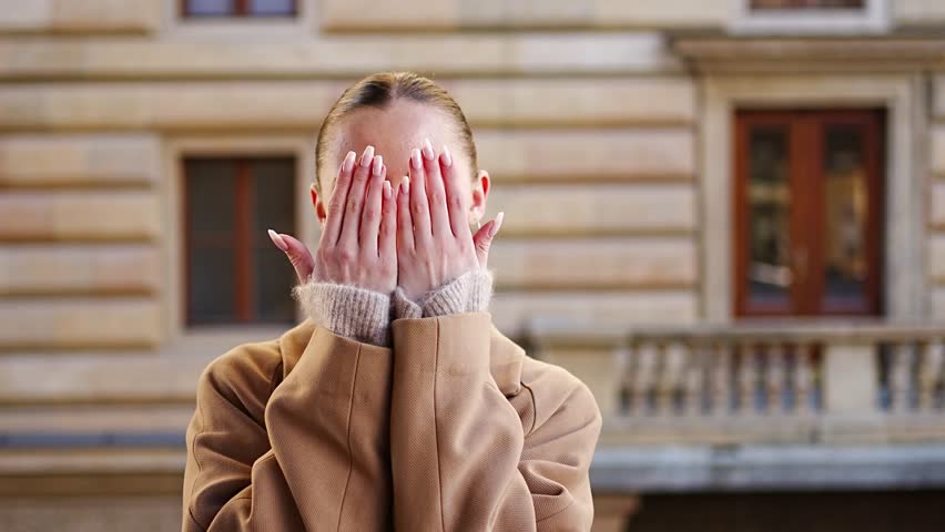 Portrait of young playful woman wearing coat in the city centre of Prague, Europe. High quality 4k footage