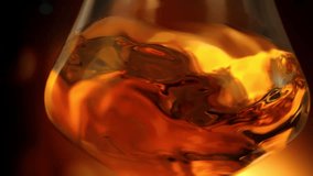 Super Slow Motion Detail Shot of Swirling Golden Alcohol in Glass at 1000fps. - Powered by Shutterstock - Get 15% off with code: PIKWIZARD15