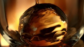 Super Slow Motion Detail Shot of Pouring Whiskey on Ice Sphere in Glass at 1000fps. - Powered by Shutterstock - Get 15% off with code: PIKWIZARD15