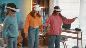 Excited teen girls talking before entering virtual reality by putting on VR headset goggles to play virtual video games standing in the room at home - Powered by Shutterstock - Get 15% off with code: PIKWIZARD15