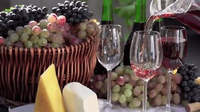 Pouring a Glass of Rose Wine. In pouring a glass of wine on the background of a basket with grapes, wine bottles and pieces of cheese. Slow Motion - Powered by Shutterstock - Get 15% off with code: PIKWIZARD15