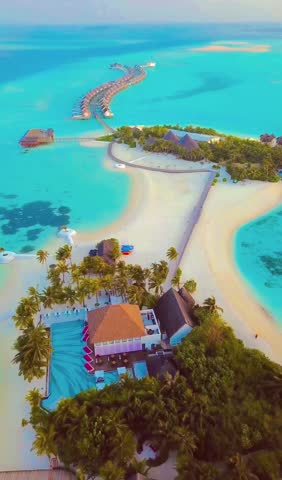 In the Maldives, the luxury of bungalows over turquoise waters arcs in perfect harmony, while white sandy shores and swaying palms frame an idyllic paradise. True bliss.
