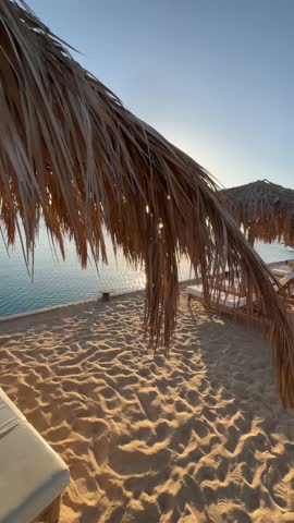 This breathtaking footage captures the mesmerizing sunrise over the Red Sea in Hurghada, Egypt. The golden sun slowly rises above the horizon, casting a warm glow over the calm waters and sandy beache