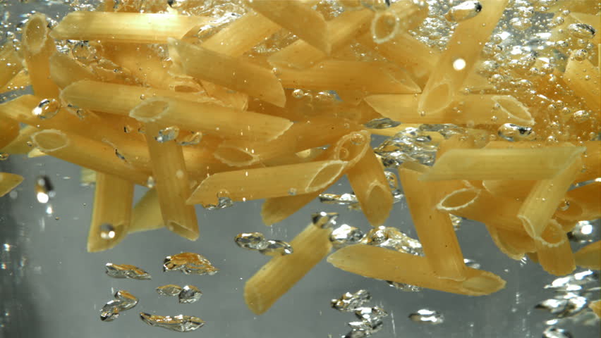 Penne pasta falls into boiling water. Filmed on a high-speed camera at 1000 fps. High quality FullHD footage