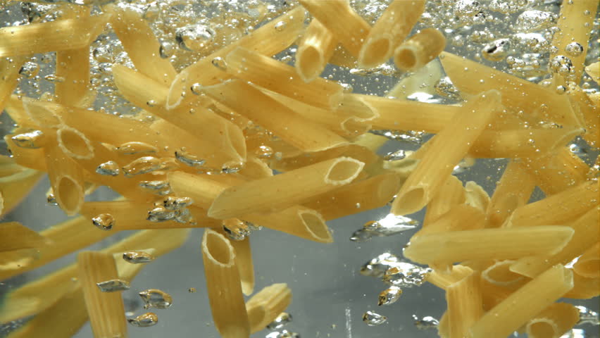 Penne pasta falls into boiling water. Filmed on a high-speed camera at 1000 fps. High quality FullHD footage