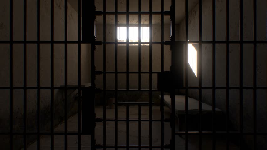 Time passes from morning to evening as sunlight moves across a minimal prison cell containing just a cot, table, and bucket. A high-security, no-frills environment.