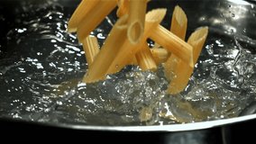 Penne pasta falls into boiling water. Filmed on a high-speed camera at 1000 fps. High quality FullHD footage - Powered by Shutterstock - Get 15% off with code: PIKWIZARD15