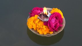 hinduism religious ceremony puja flowers and candle on Ganges water, India