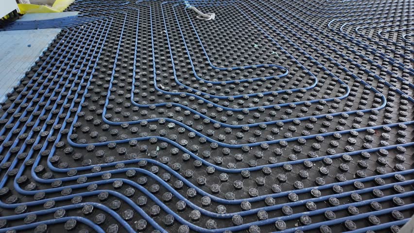 System of underfloor heating. Installation of a heat flooring system. Modern heating system in a new home