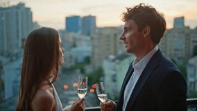 Lovely couple clinking champagne standing restaurant terrace at twilight closeup. Enamoured pair holding wine glasses spending romantic date on rooftop. Smiling lovers talking enjoying relationship. - Powered by Shutterstock - Get 15% off with code: PIKWIZARD15