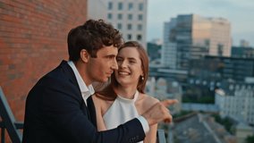 Enamoured couple talking on date enjoying time together outdoors closeup. Romantic spouses standing on balcony looking dusk city view. Smiling man showing cityscape to happy woman on building rooftop - Powered by Shutterstock - Get 15% off with code: PIKWIZARD15