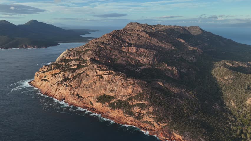 Rocky mountain in Freycinet National Park surrounding Coles Bay in Tasmania, Australia. Aerial drone panoramic view at sunset
