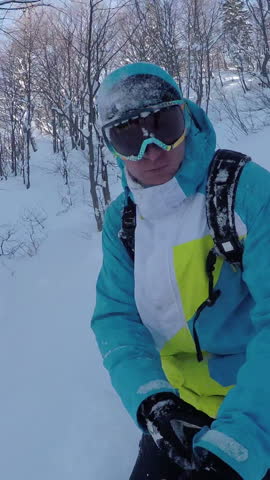 SELFIE: Snowboarder riding powder between the trees