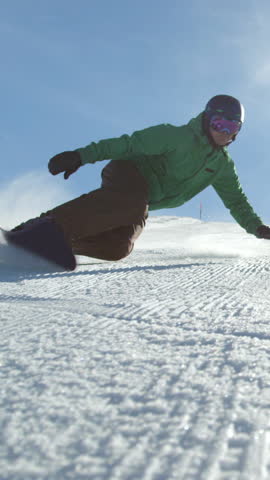 SLOW MOTION: Race snowboarder carving down the icy ski slope