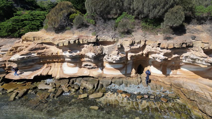 A pull-back aerial footage of the scenic Painted Cliffs on Maria Island, on a sunny day in Tasmania, Australia