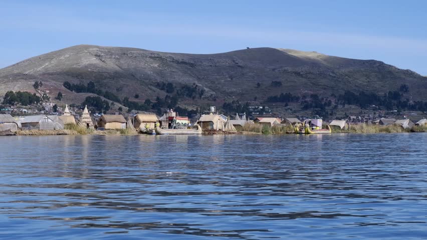 View of Uros Islands in Lake Titicaca from boat motoring past, Peru