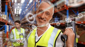 Animation of network of connections with icons over caucasian male workers working in warehouse. Global business, teamwork and digital interface concept digitally generated video. - Powered by Shutterstock - Get 15% off with code: PIKWIZARD15