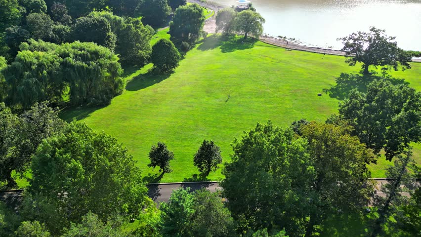 The aerial perspective showcases an expansive field within a picturesque park, highlighting the various sporting activities that unfold and the joy derived from engaging in outdoor pursuits on a brigh
