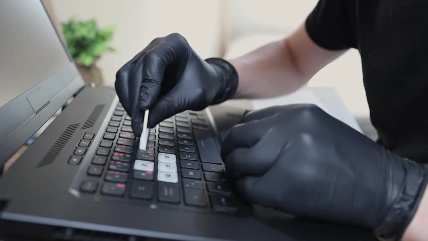One young man puts stickers on his laptop keyboard.