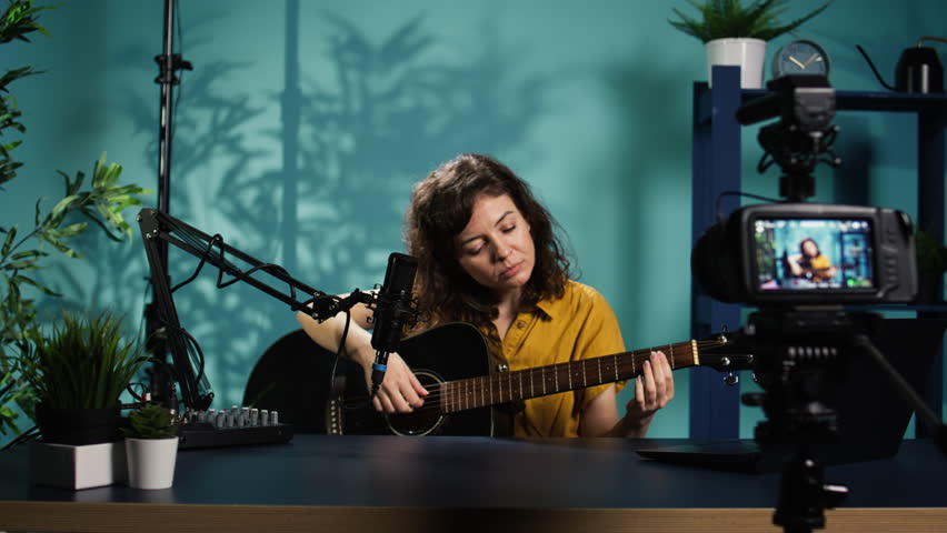 Content creator playing music on guitar during livestream with subscribers online. Skilled artist using acoustic musical instrument, doing internet concert for viewers, camera B