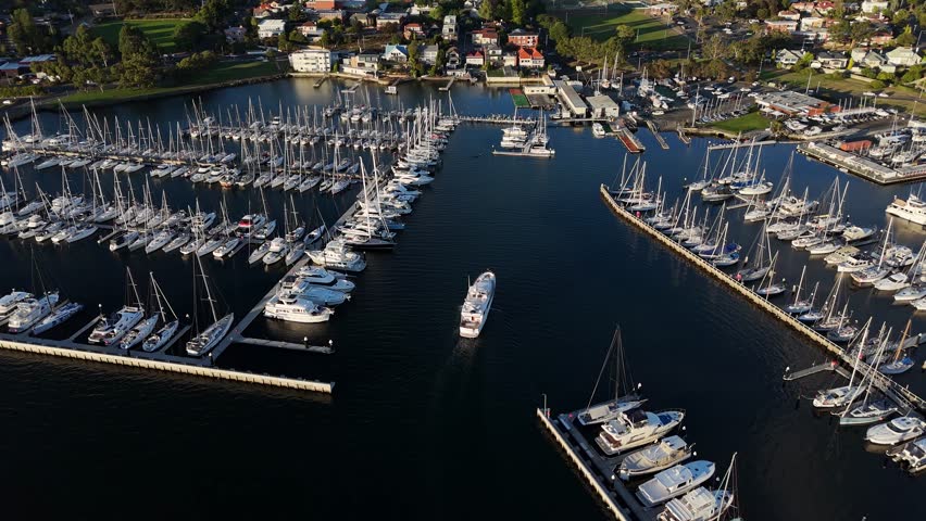 Boat entering in port of Royal Yacht Club of Tasmania at sunset, Hobart in Australia. Aerial drone view