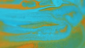 Paint blot. Shiny fluid blend. Defocused orange golden blue cyan color sparkling glitter sand particles ink splash acrylic dye liquid spill motion abstract art background. - Powered by Shutterstock - Get 15% off with code: PIKWIZARD15