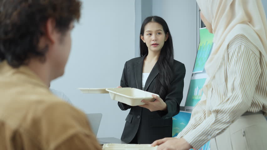 Diverse team of professionals examines eco-friendly packaging options in a collaborative meeting, focusing on sustainable business practices and innovation.