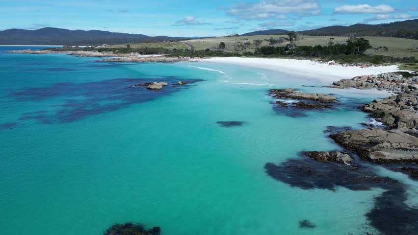 An aerial footage of the scenic Bay of Fires Conservation Area and Gardens Lagoon Beach on a sunny day in Tasmania, Australia
