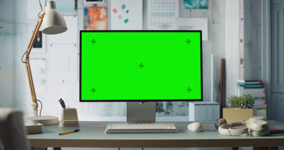 Desktop Computer With a Green Screen Monitor Sits on a Desk in an Office. Chroma Key Display with Clean, Technical, Engineering and Creative Industrial Design Background. Zoom in Shot