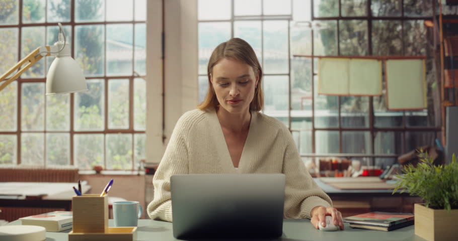 White Woman Uses a Laptop in a Sunlit Office. Successfull White Woman Working on Computer, Doing Digital Company Marketing, Creative Writing, Coding, Research. Front View Portrait