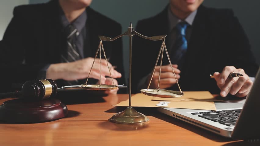 Business and Legal Experts Reviewing Contract Documents in Office with Brass Scale of Justice on Desk, Offering Professional Legal Services and Advice on Law and Justice in Corporate Transactions