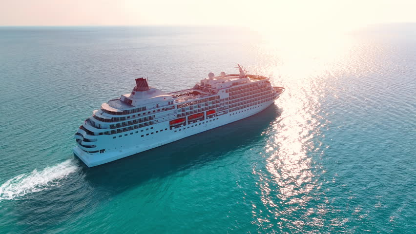 Cruising over bright turquoise waters on a luxury ship near stunning coastal scenery at sunset