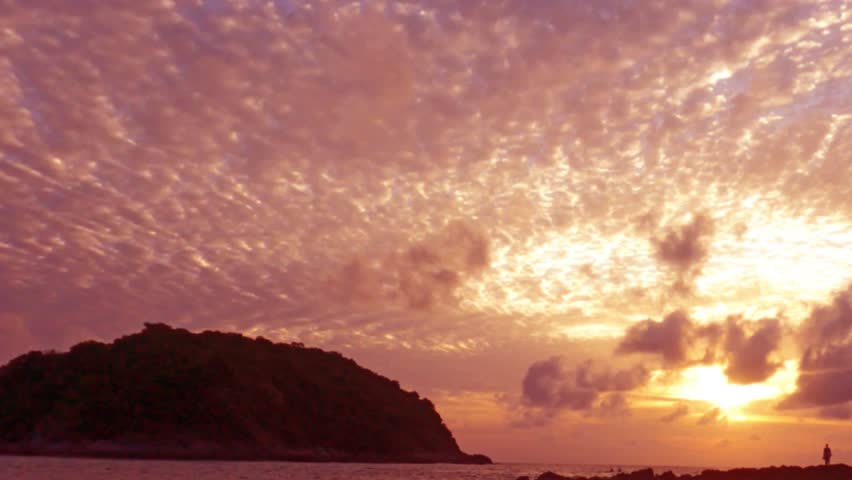 Beautiful sunset n golden red pink cloud or cloudscape on purple blue sky with silhouette couple take photo or vdo on island rock beach in tropical summer sunlight n sun ray, Slow motion 4k TimeLapse