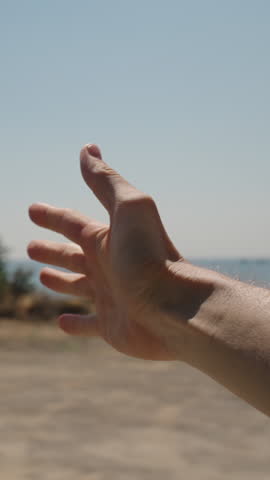 Vertical video. A Man's Hand Reaching Out from a Car Window, Feeling the Breeze. The Clear Blue Sky and Ocean in the Background Create a Serene and Refreshing Scene, Capturing a Simple Moment of Joy D
