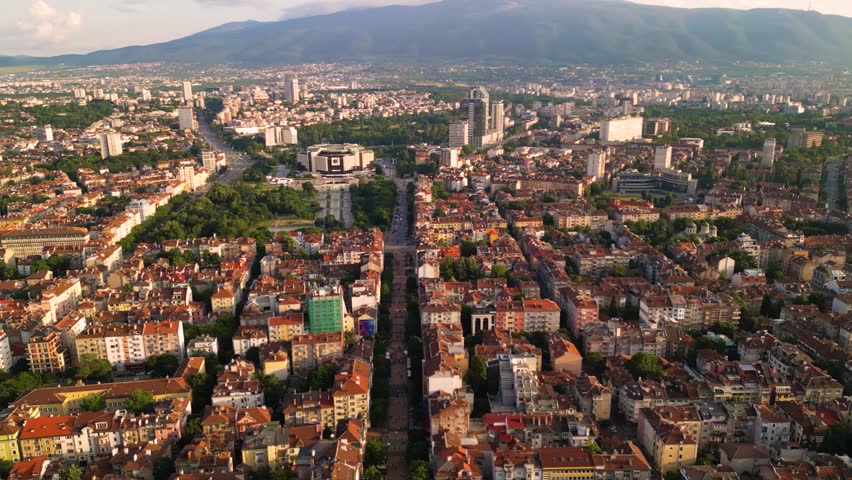 Aerial footage of the city center of Sofia Bulgaria. Main pedestrian street, City Court, National Palace of Culture, Vitoshka boulevard. Sunny view golden hour of european capital architecture.
