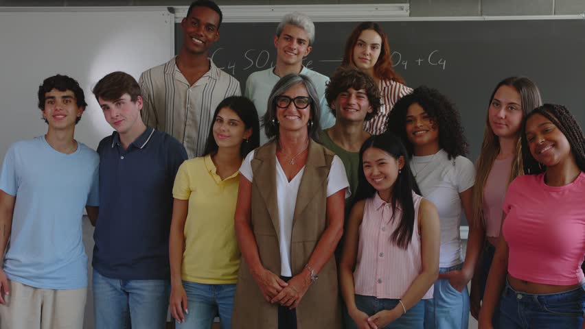 Portrait group of multiracial high school students with senior teacher in classroom. Waving hand to the camera. Education and youth community concept