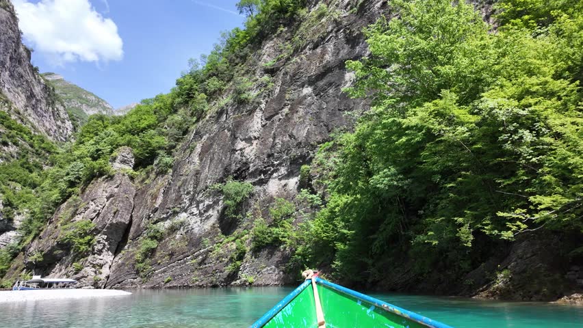 A mountain landscape view from a boat sailing on Komani lake on a sunny day in the summertime in Albania