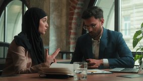 Multiracial business partners male female businessman businesswoman colleagues office meeting conversation teamwork Muslim mentor woman in hijab consulting Arabian man client discuss paperwork graphs - Powered by Shutterstock - Get 15% off with code: PIKWIZARD15
