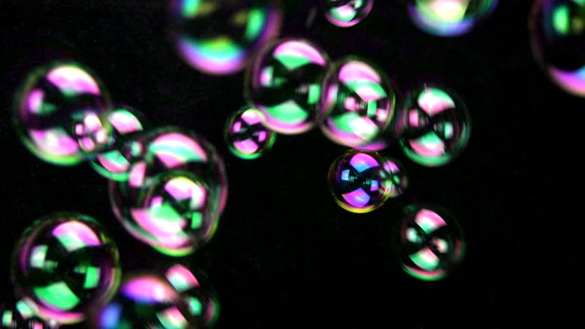 Abstract background from soap iridescent bubbles, which fly. A black background