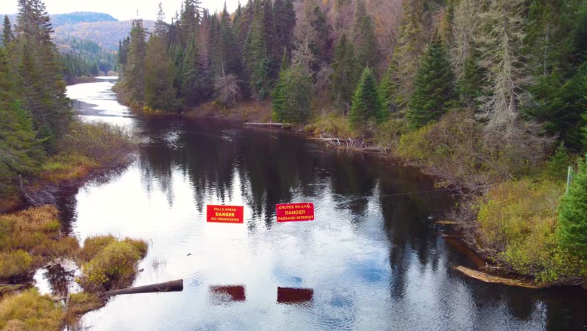 Danger sign over the river somewhere at Mont Tremblant forests, Québec, Canada.