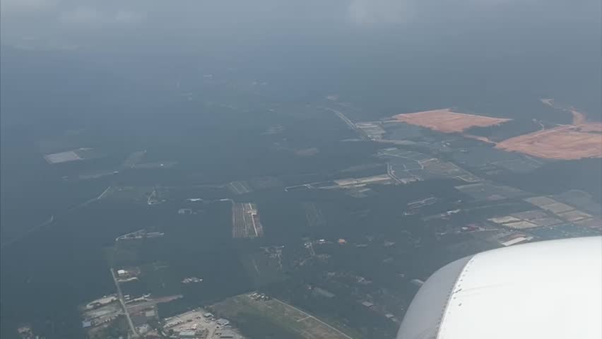Cityscape around of Kuala Lumpur International Airport seen from the aircraft cabin.