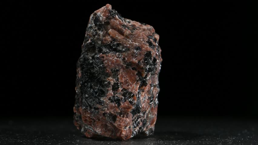 Granodiorite (phaneritic-textured intrusive igneous rock similar to granite, but with more plagioclase feldspar than orthoclase feldspar) rotating slowly against a black background [Norway]