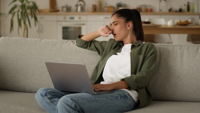 Tired exhausted fatigued Indian woman Arabian girl female Muslim lady at home couch feel luck energy tiredness overworked insomnia sleep yawn typing laptop computer yawning working studying distant - Powered by Shutterstock - Get 15% off with code: PIKWIZARD15