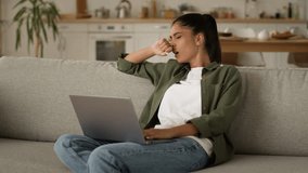 Tired exhausted fatigued Indian woman Arabian girl female Muslim lady at home couch feel luck energy tiredness overworked insomnia sleep yawn typing laptop computer yawning working studying distant - Powered by Shutterstock - Get 15% off with code: PIKWIZARD15