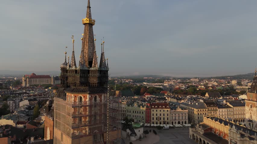 Aerial view of the Church of the Assumption of the Blessed Virgin Mary Bazylika Mariacka on the Market Square in the central historical tourist part of Krakow at sunset, Poland