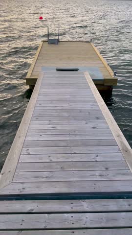 Empty wooden jetty extending over calm waters at sunset