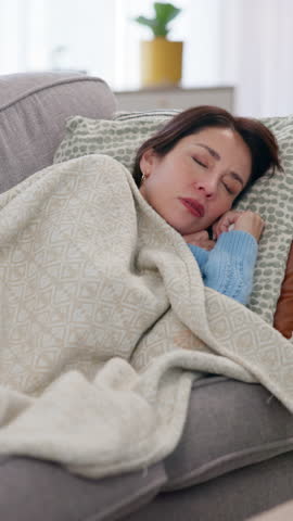 Sick, woman and sleeping for cold, flu and illness with blanket for wellness and comfort on living room sofa. Girl, sneezing and recovery for health, virus or allergy with rest and relax in house