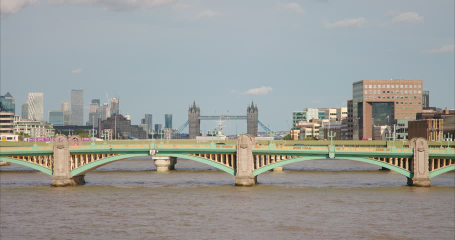 A beautiful view of a bridge over the Thames River with the iconic architecture of London in the background. Captured in stunning 8K resolution.