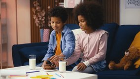 African American children eating cookies and drinking milk, having lunch at home - Powered by Shutterstock - Get 15% off with code: PIKWIZARD15